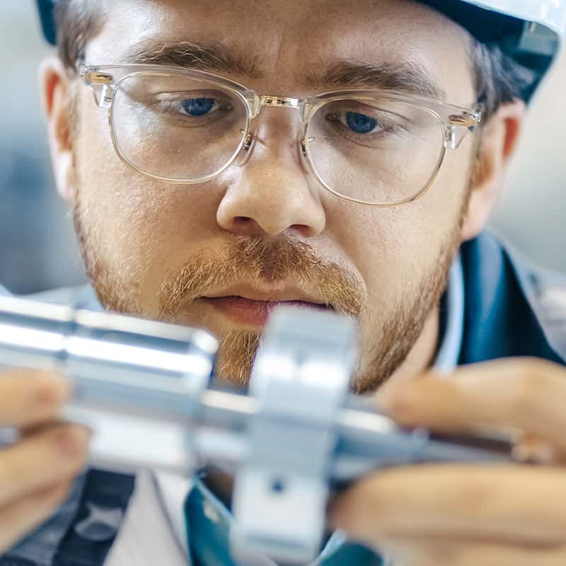 worker inspecting a metal bolt tensioning tool